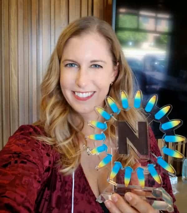 Julie Zagars holding a Naturally Boulder Award.